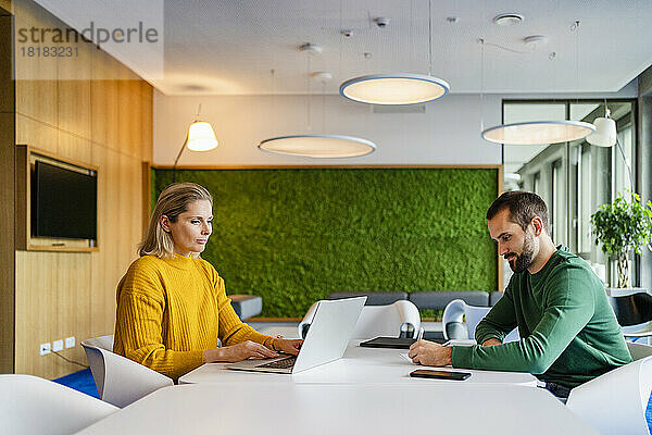Geschäftskollegen arbeiten gemeinsam am Schreibtisch an einem modernen Arbeitsplatz