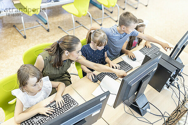 Schüler lernen E-Learning mit dem Lehrer im Computerunterricht in der Schule