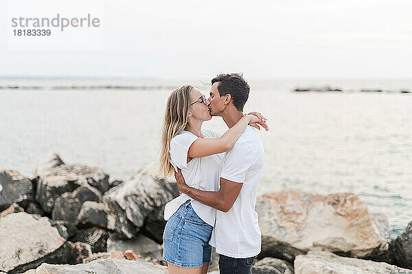 Paar umarmt und küsst sich am Strand