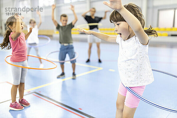 Schüler üben gemeinsam Hula-Hoop-Reifen auf dem Schulsportplatz