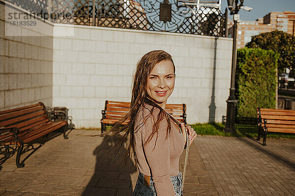 Schöne lächelnde Frau im Park an einem sonnigen Tag