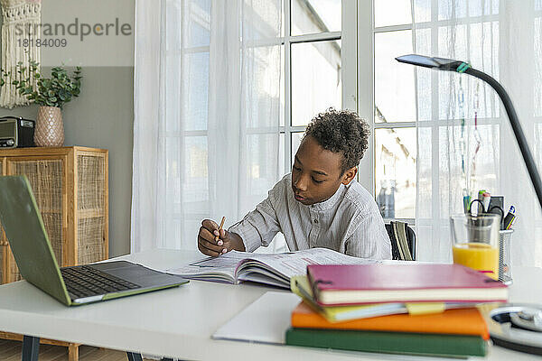 Junge lernt zu Hause am Tisch