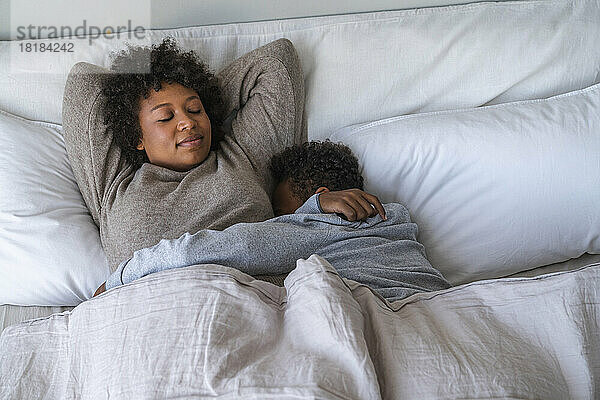 Mutter und Sohn schlafen zu Hause im Bett