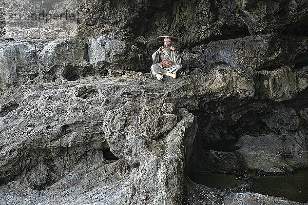 Mönch übt Meditation auf einem Felsen