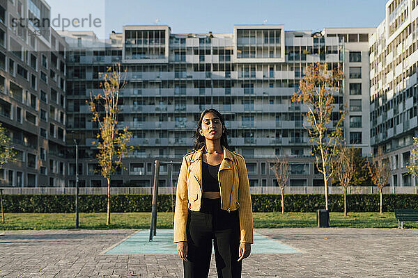 Young woman standing in front of residential buildings