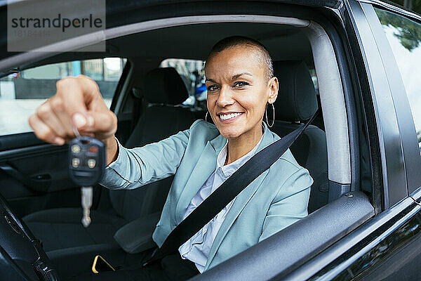 Lächelnde Geschäftsfrau zeigt Autoschlüssel
