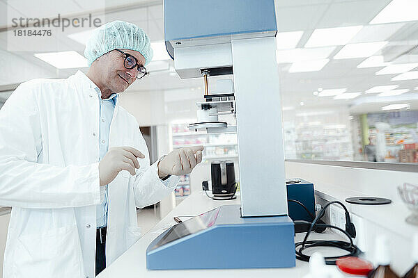 Lächelnder Chemiker mit Brille experimentiert im Labor