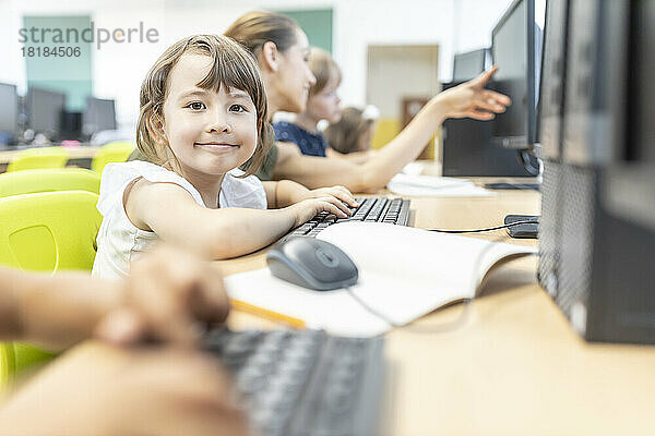 Lächelnder Schüler im Computerunterricht in der Schule