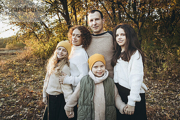 Glücklicher Mann steht mit Familie im Herbstwald