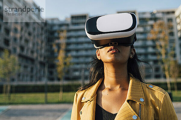Junge Frau trägt an einem sonnigen Tag einen Virtual-Reality-Simulator