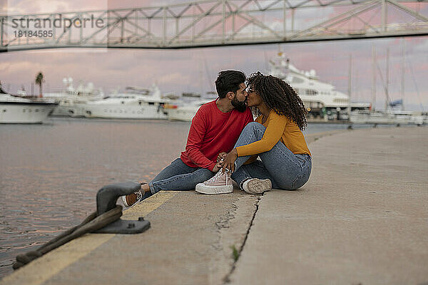Romantic young couple kissing on promenade at sunset