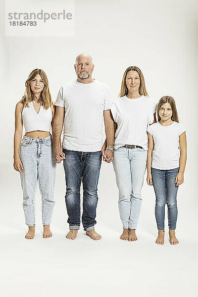 Mutter und Vater mit Töchtern vor weißem Hintergrund