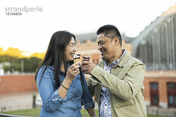 Happy mature couple having ice cream cone together on weekend