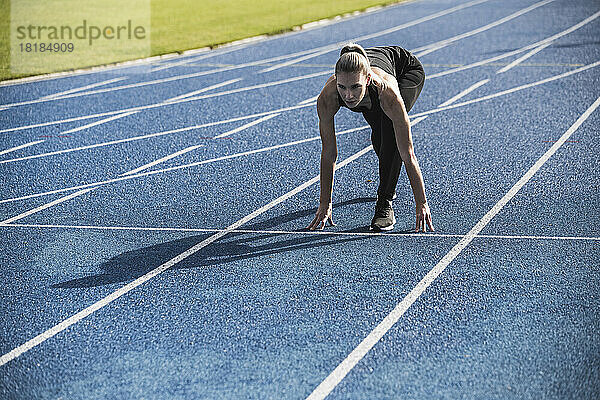 Young athlete at starting line of track
