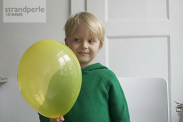 Porträt eines lächelnden kleinen Jungen mit Ballon