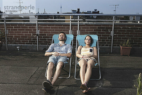Deutschland  Berlin  Paar entspannt auf Dachterrasse