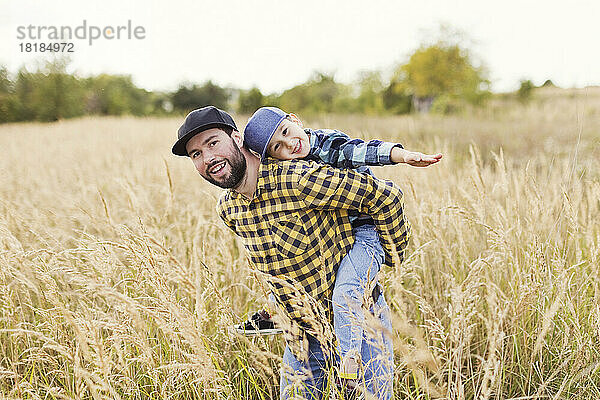 Vater und süßer Junge haben Spaß auf dem Feld