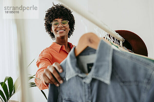 Lächelnde Geschäftsfrau mit Brille und Kleidung im Heimbüro