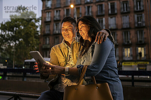 Älteres Paar schaut nachts auf den Tablet-PC