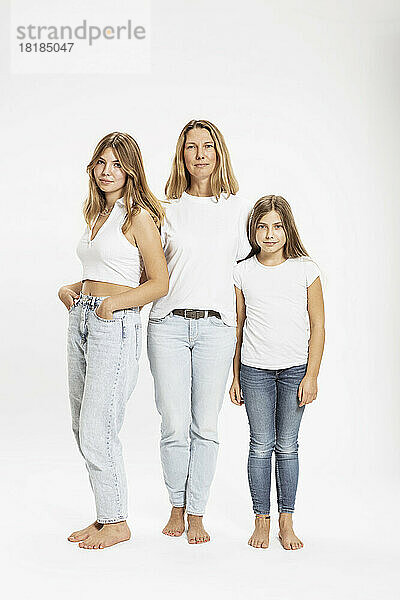 Mutter mit Töchtern  die vor weißem Hintergrund stehen