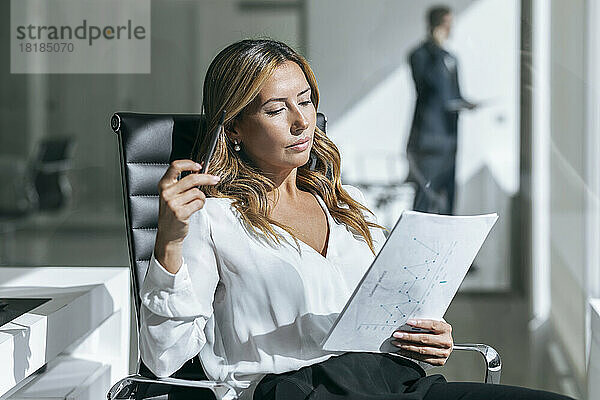 Geschäftsfrau liest Dokument im Büro