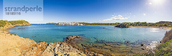 Spanien  Balearen  Menorca  Panoramablick auf die Bucht im Sommer mit einem Dorf im Hintergrund