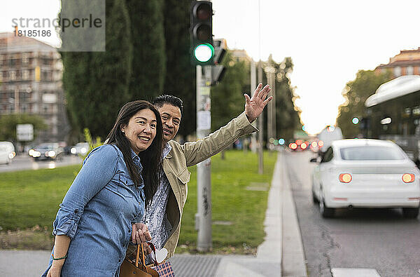Lächelnde Frau steht neben Mann und begrüßt den Fußweg an der Straße
