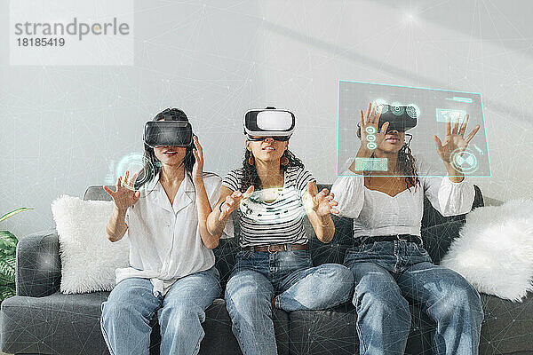 Freunde  die zu Hause eine VR-Brille benutzen und gestikulieren