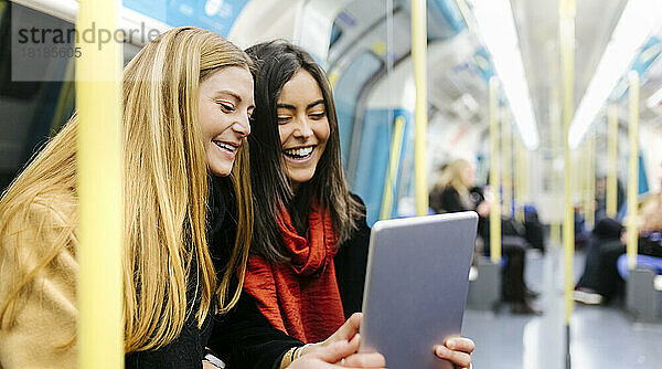 Großbritannien  London  zwei junge Frauen in der U-Bahn mit digitalem Tablet