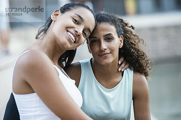 Smiling teenage girl sitting with friend
