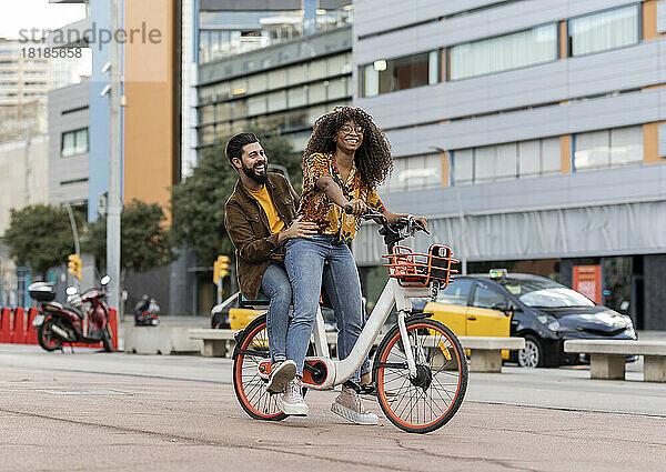 Glücklicher Freund genießt es  mit seiner Freundin Fahrrad am Fußweg zu fahren