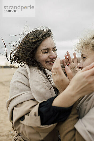 Happy woman enjoying with mother at beach
