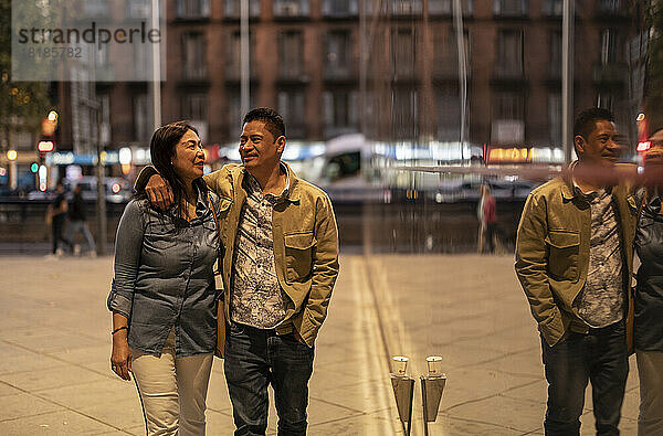 Lächelndes älteres Paar  das nachts auf dem Fußweg spaziert