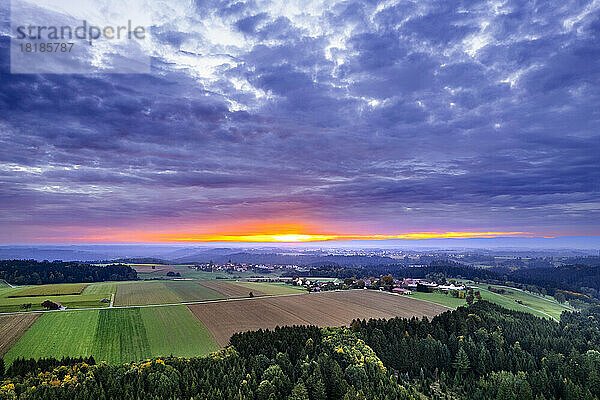 Deutschland  Baden-Württemberg  Dramatische Wolken über Feldern im Schwäbisch-Fränkischen Wald bei Sonnenaufgang