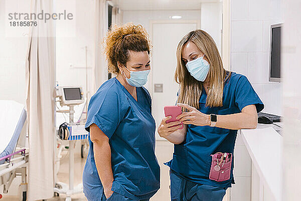 Krankenschwester und Kollegin nutzen Smartphone im Krankenhaus