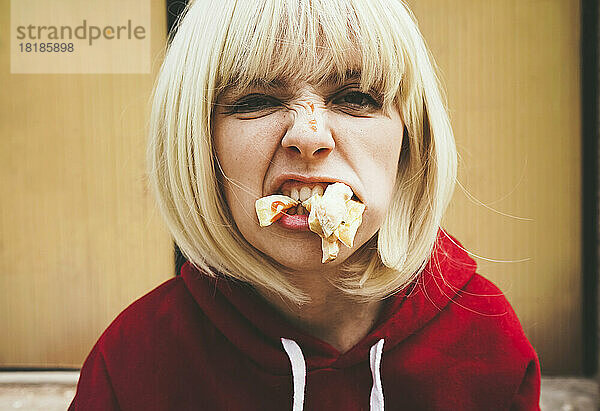 Frau mit blonden Haaren isst Pommes frites