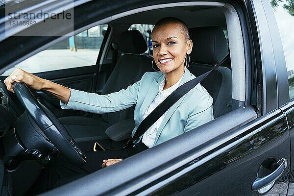 Lächelnde Geschäftsfrau  die im Auto sitzt