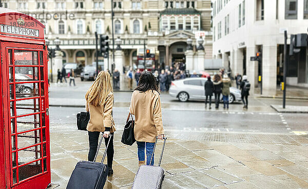Großbritannien  London  zwei Freunde erkunden die Stadt und kommen mit Trolley-Taschen an