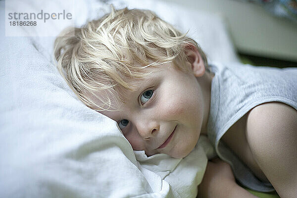 Porträt eines kleinen Jungen  der im Bett liegt