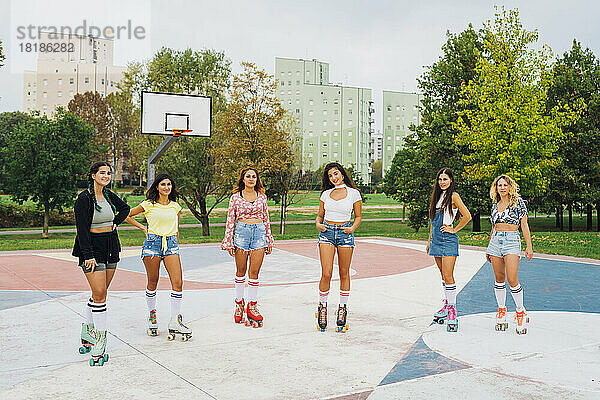 Lächelnde Freunde stehen zusammen am Basketballplatz