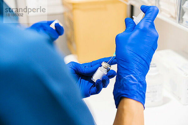 Hände einer Krankenschwester  die in der medizinischen Klinik eine Spritze vorbereitet