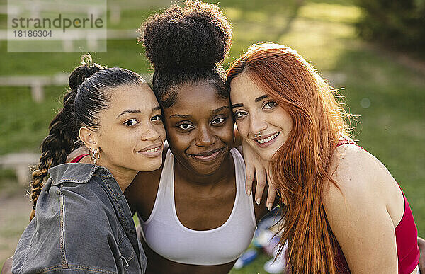 Glückliche junge Frauen stehen zusammen im Park