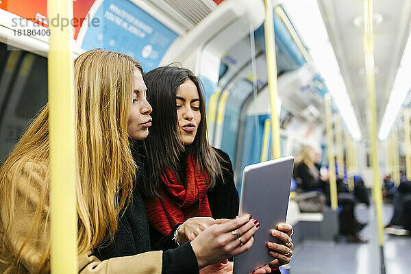 Großbritannien  London  zwei junge Frauen in der U-Bahn mit digitalem Tablet