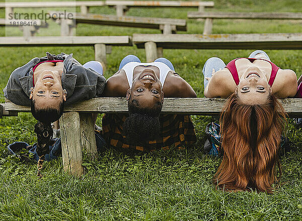 Glückliche junge Frauen  die auf einer Bank im Park ruhen