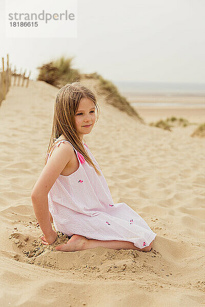 Porträt eines Mädchens  das am Strand sitzt