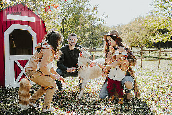 Lächelnde Eltern mit Kindern im Fuchskostüm auf dem Bauernhof