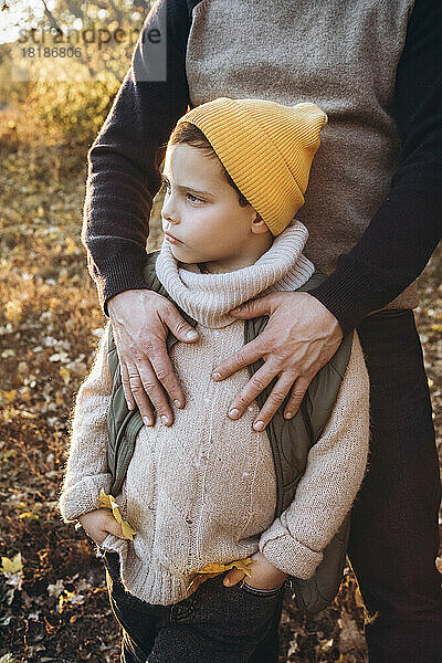 Junge mit Strickmütze steht beim Vater