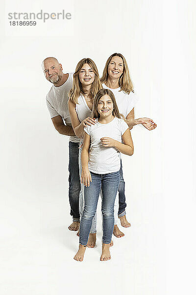 Lächelnde Töchter und Eltern vor weißem Hintergrund