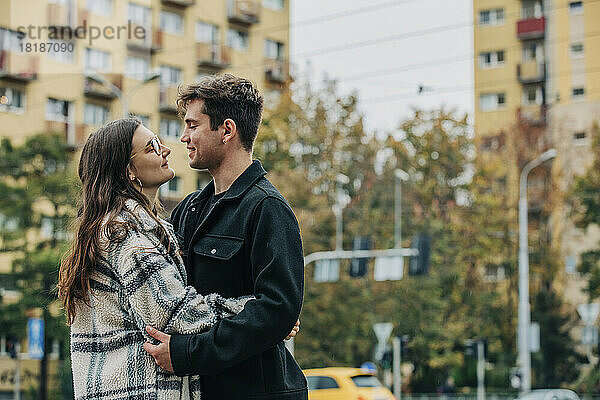 Lächelndes junges Paar  das sich in der Stadt umarmt