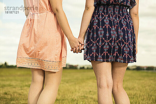 Two young women walking hand in hand  close-up